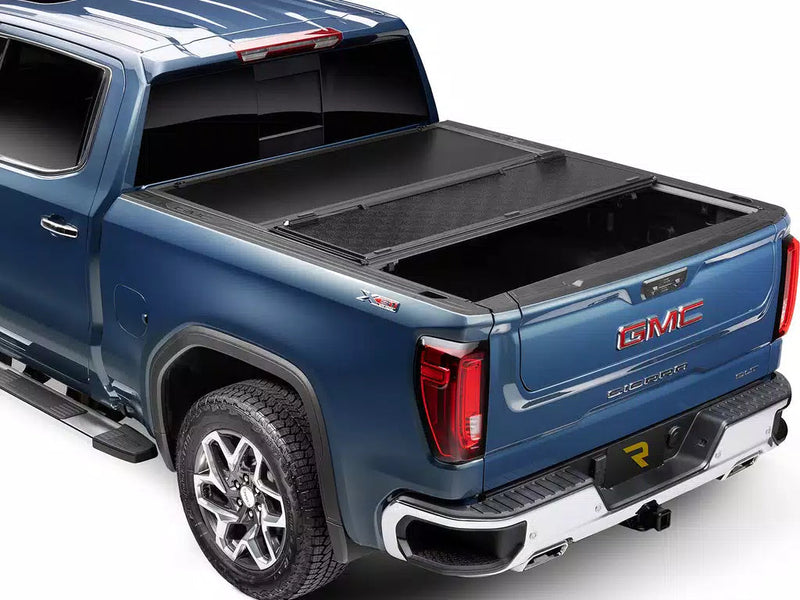 UnderCover Select hard folding tonneau cover part-open with the rear panel folded forward over the middle panel, rear three-quarter view.