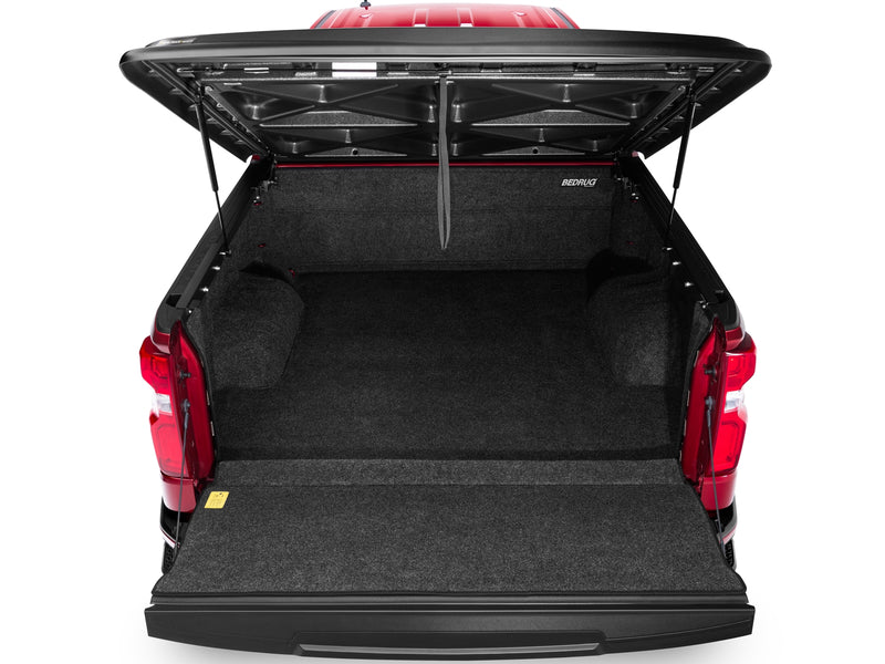 UnderCover SE one-piece tonneau cover raised with the tailgate down, straight rear view over the dropped tailgate into the open bed.