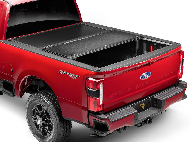 UnderCover Select hard folding tonneau cover part-open with the rear panel folded forward over the middle panel, rear three-quarter view.