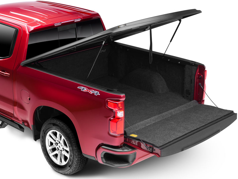 UnderCover SE one-piece tonneau cover raised with the tailgate down, rear three-quarter view, the bed floor open the whole length of the box.