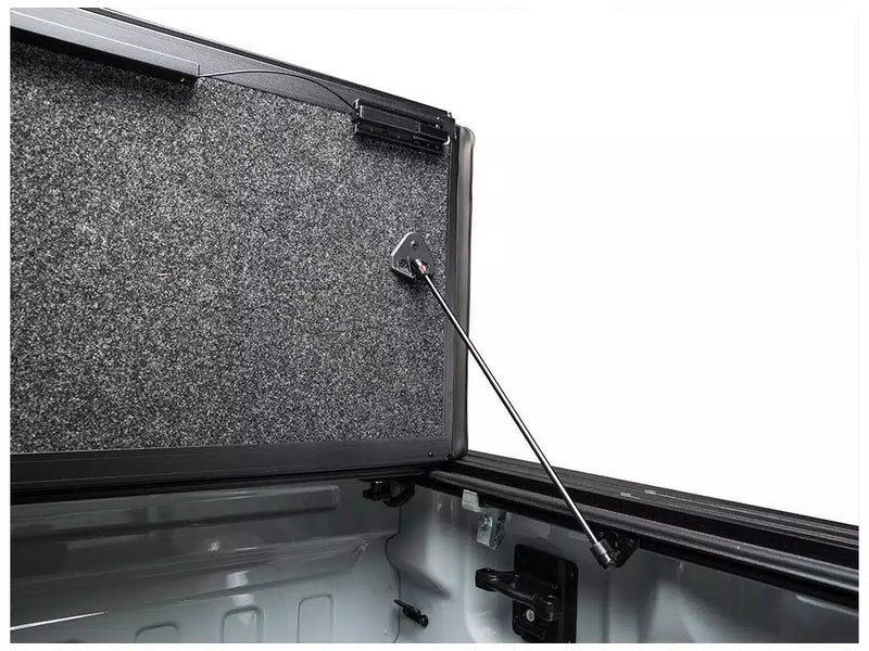 Close-up of an Ultra Flex panel held open by its prop rod, showing the rod's upper bracket on the panel's grey underside and its lower socket on the bed rail.