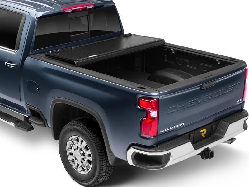 UnderCover Flex hard folding tonneau cover part-open with the rear panel folded forward, about a third of the bed exposed, rear three-quarter view.