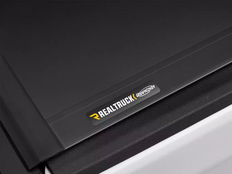 Close-up of the Ultra Flex cover's matte-black panel and rear edge with the RealTruck UnderCover nameplate.