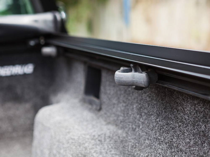 Close-up of the side rail with a plastic tie-down cleat above a carpeted bed liner