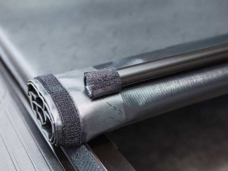 Close-up of the rolled cover with its hook-and-loop storage strap