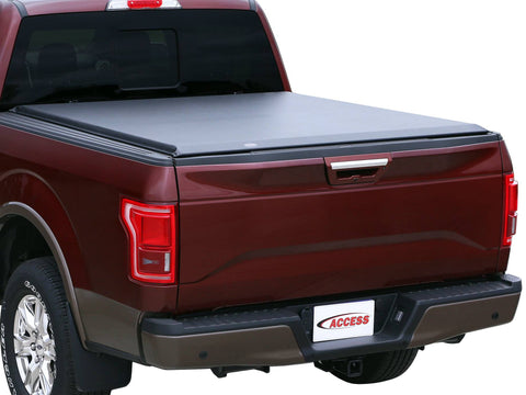 Rear three-quarter studio view of a red crew cab pickup with the black roll-up cover closed flush over the bed (brand plate on the bumper)