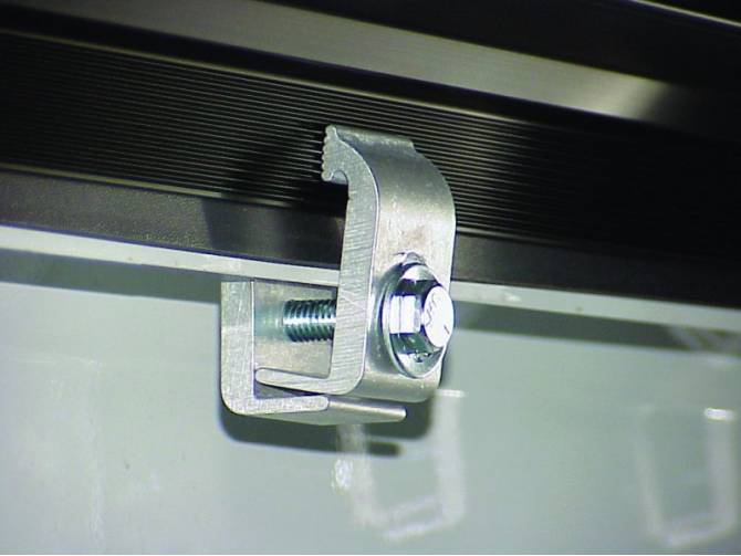 Close-up of the zinc C-clamp that fixes the side rail to the bed wall
