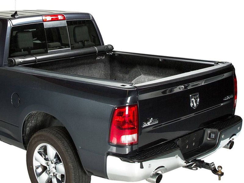 Soft roll-up cover rolled tight against the cab with the full bed open, studio white background