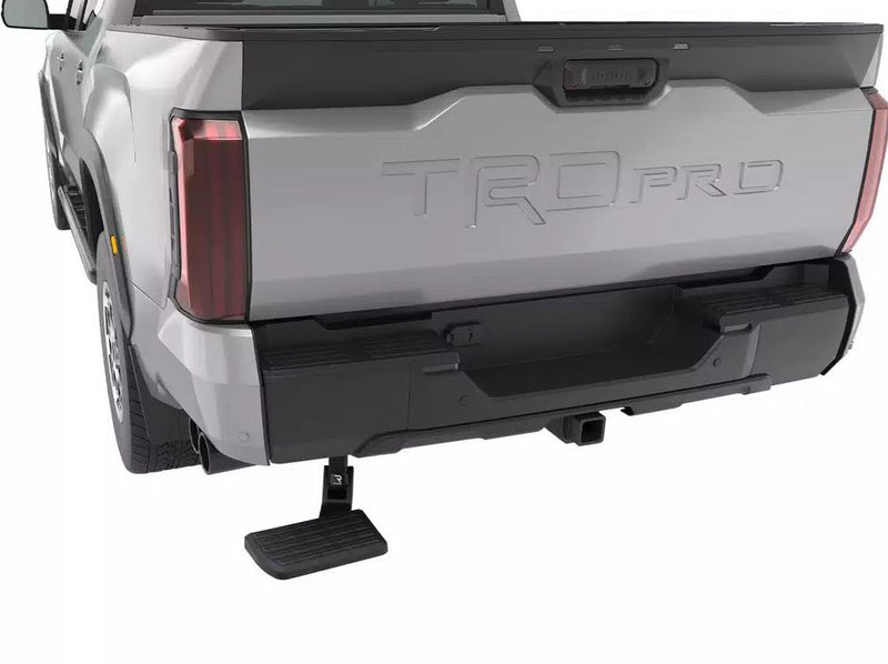 BedStep deployed below the rear bumper of a silver pickup, rear three-quarter studio view