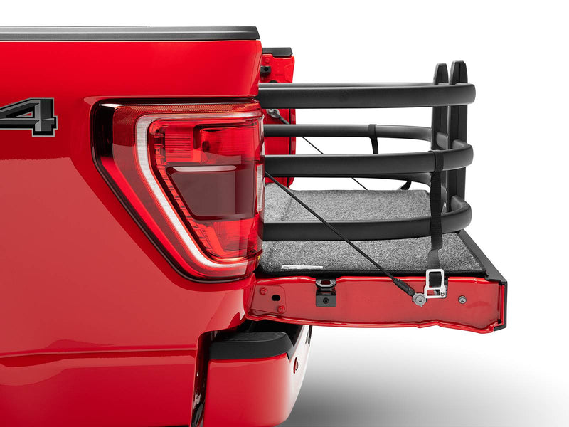 BedXTender HD Max extended over the lowered tailgate beside the tail lamp of a red pickup