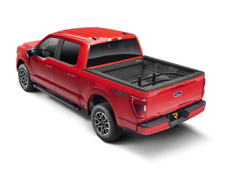 Red crew-cab pickup with the tailgate closed and the BedXTender HD Max flipped inside the bed as a cargo divider