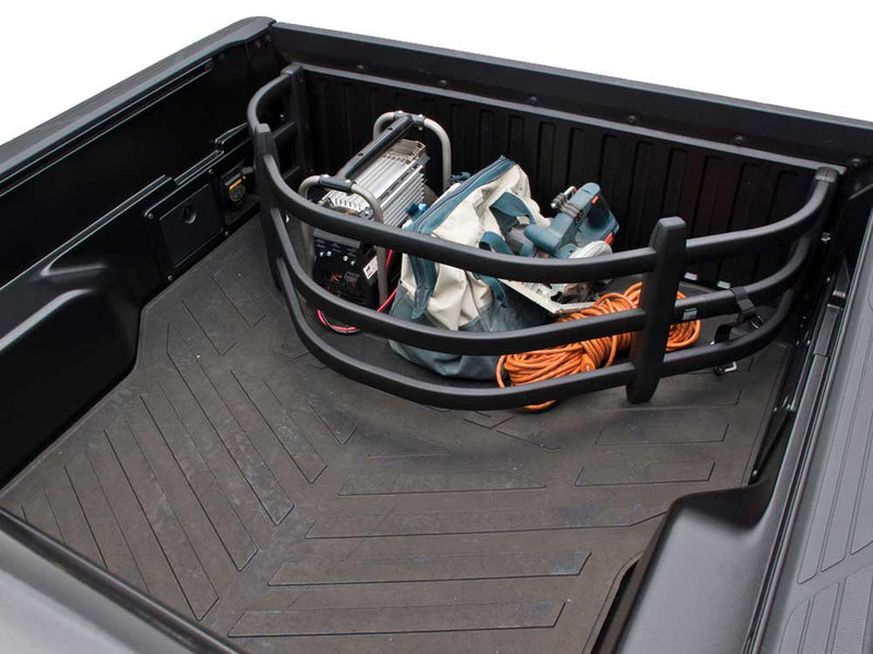 BedXTender HD Moto turned inward to corral a compressor, bag and extension cord in a gray pickup bed