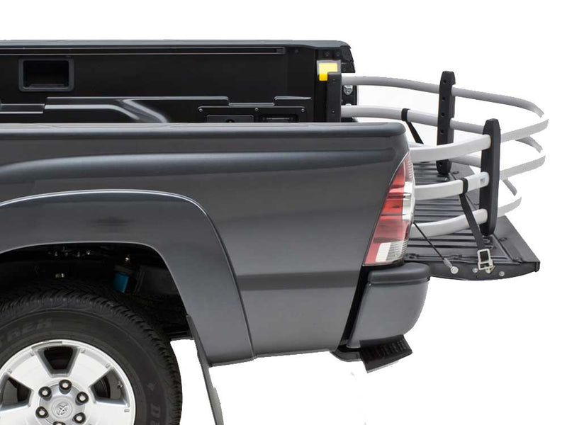 Silver BedXTender HD Moto extended over the lowered tailgate of a gray pickup, rear corner studio view