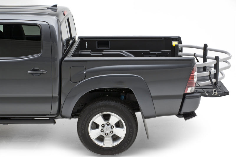 Gray crew-cab pickup in the studio with a silver BedXTender HD Moto extended over the lowered tailgate