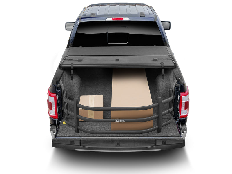 Rear view of a pickup with the BedXTender HD Sport extended over the tailgate, holding boxes