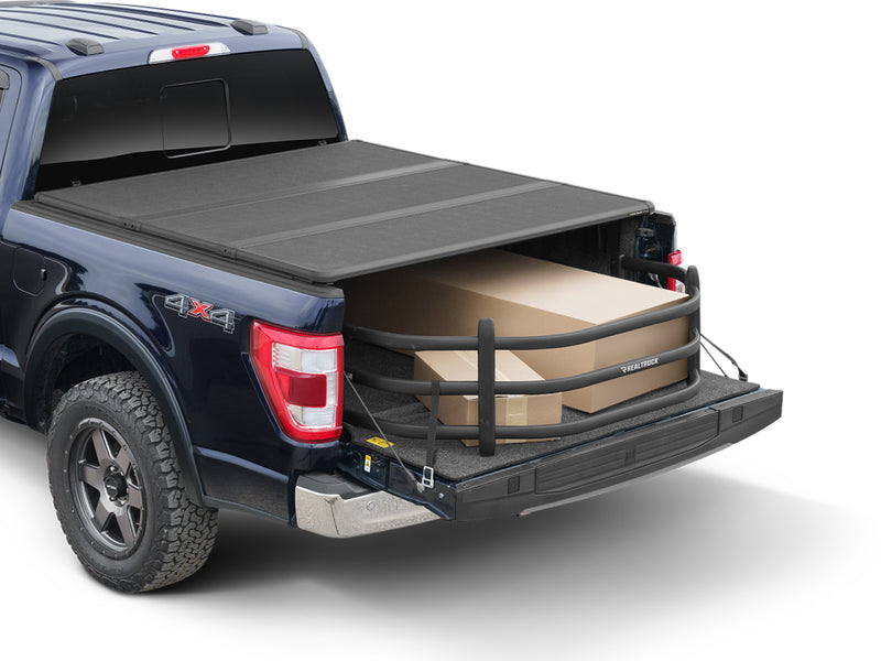 BedXTender HD Sport extended past the tailgate under a partly closed hard cover, holding long boxes