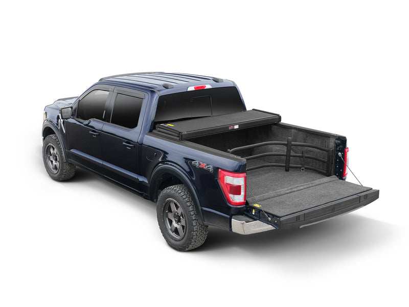 Dark blue crew-cab pickup with the BedXTender HD Sport extended over the lowered tailgate, studio