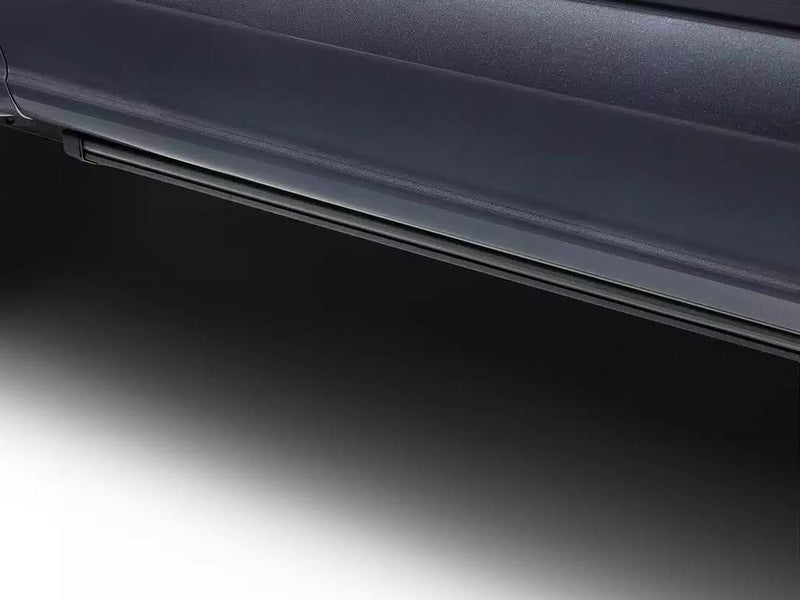 Running board tucked under the rocker of a dark vehicle, studio