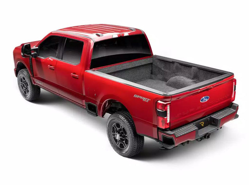 Red heavy-duty pickup in the studio, rear three-quarter view with the running board stowed