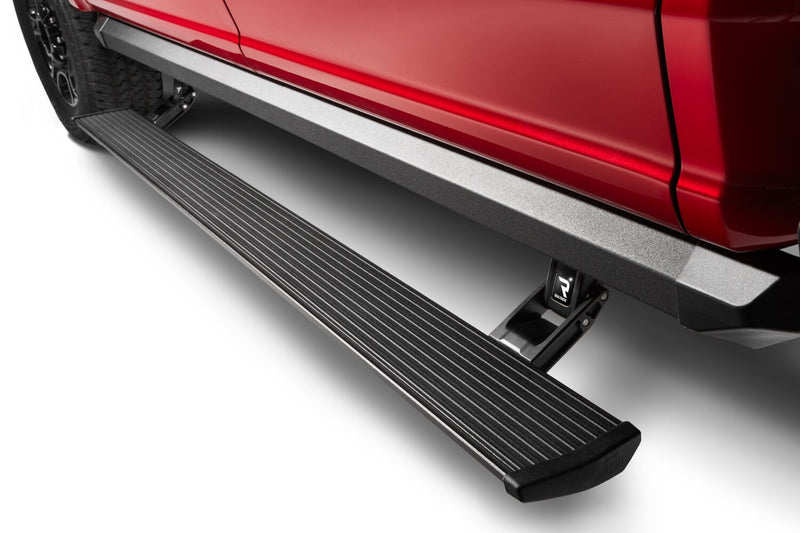 AMP Research PowerStep XL running board deployed below the doors of a red pickup, studio