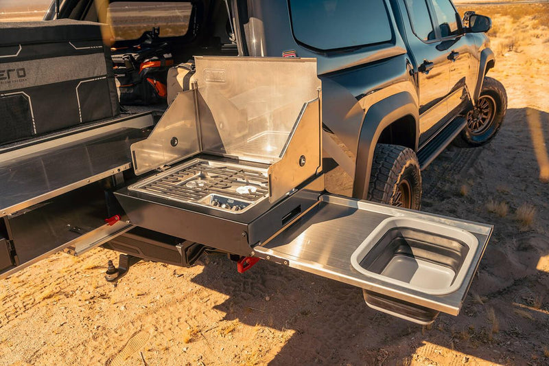 ARB slide-out camp kitchen with stove and sink deployed from the rear of a pickup