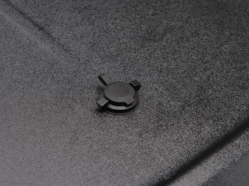 Tight macro of the SE lock knob isolated on the black textured lid surface, with the UnderCover name molded into its face.