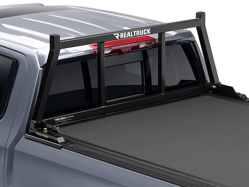 BackRack Open: A black open headache rack is mounted behind the cab of a gray GM pickup with a tonneau cover
