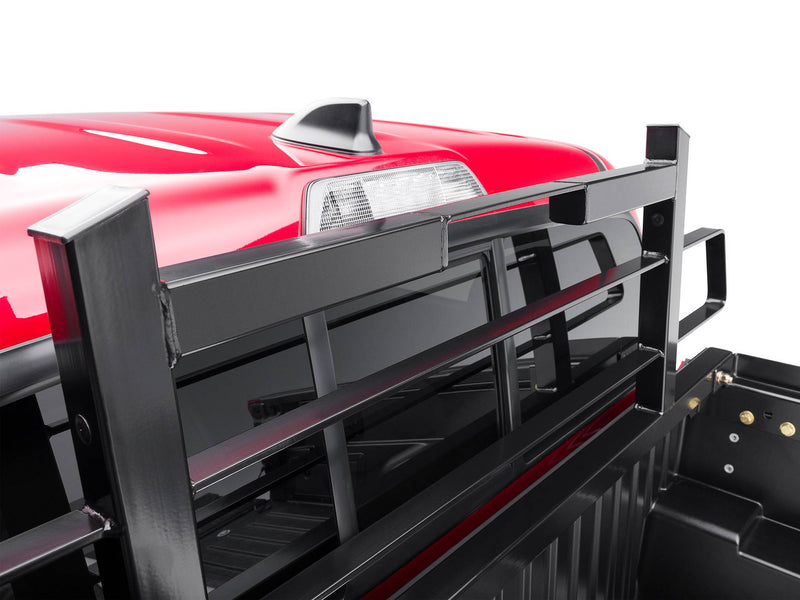 BackRack Original Short: close-up of a black Original style headache rack mounted behind the cab of a red pickup