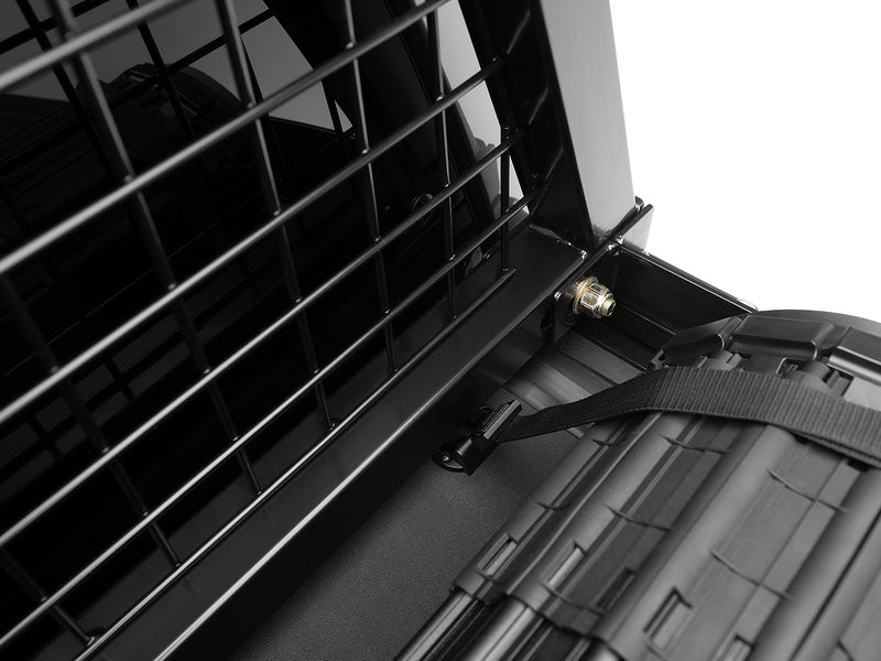 BackRack Safety: close-up of a black Safety headache rack mesh and base bracket above a rolled-up tonneau cover