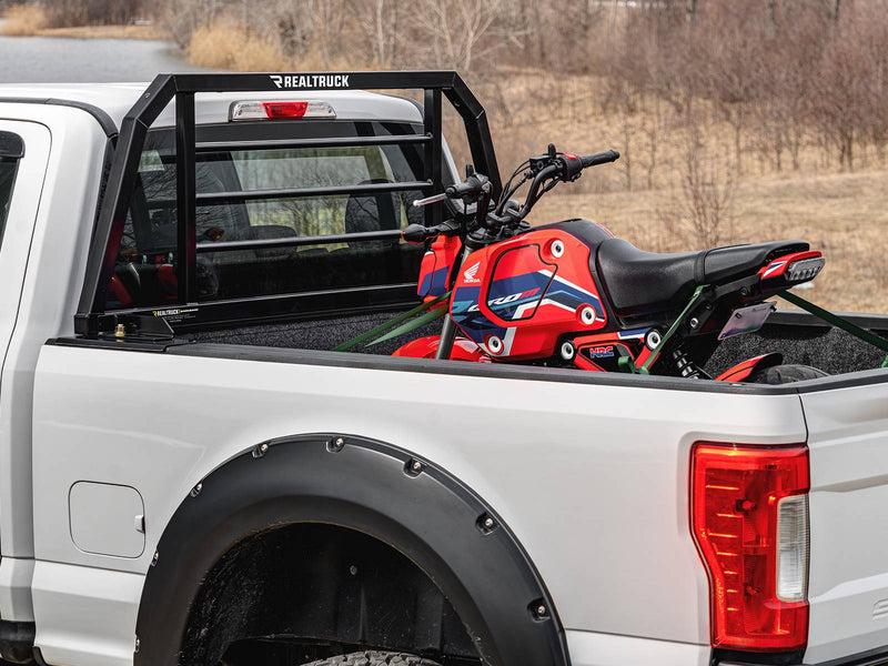 BackRack SR: A black SR headache rack behind the cab of a white Super Duty pickup with a red minibike strapped in the bed