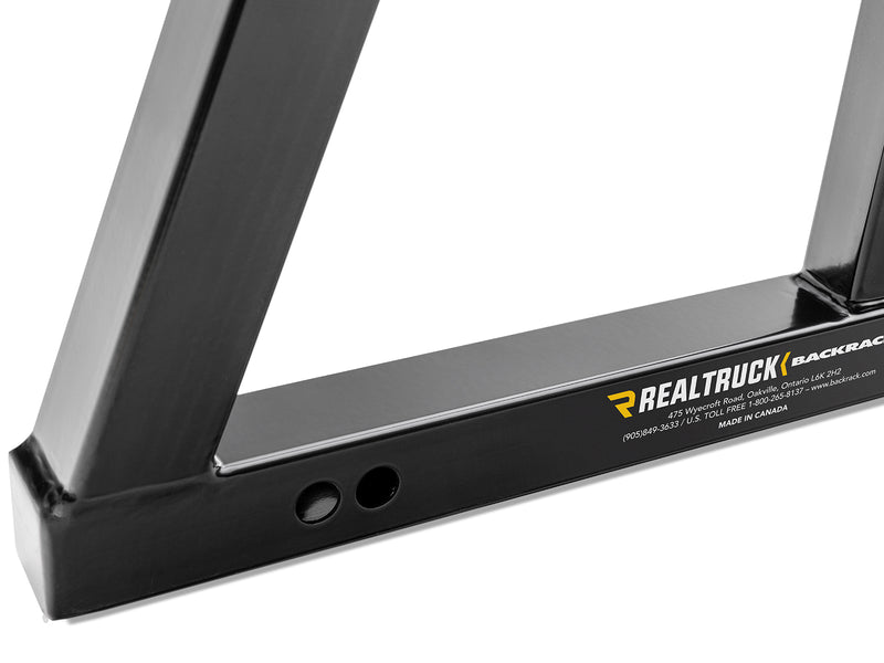 BackRack SR: close-up of the lower corner of a black headache rack showing the base tube and mounting holes