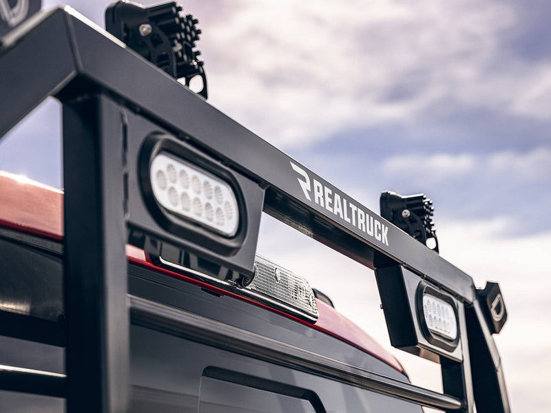 BackRack SRL: low close-up of a black SRL headache rack top bar with white oval LED lights against a cloudy sky