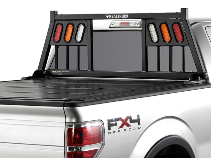 BackRack Three Light: A black headache rack with red, amber and clear oval lights in each side panel on a silver Ford F-150 FX4 with a hard folding tonneau cover