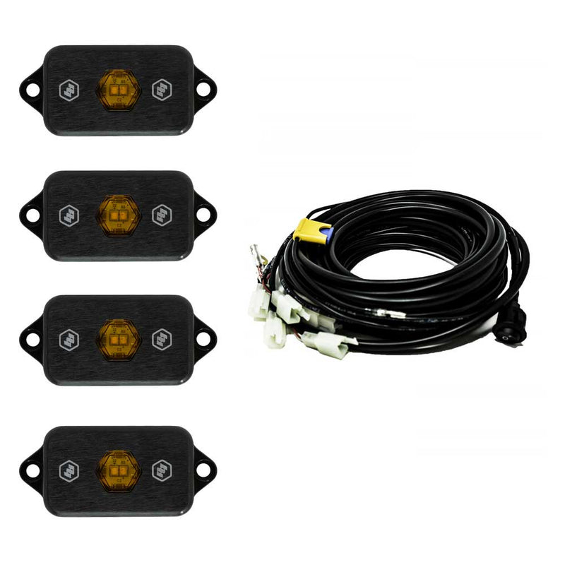 Baja Designs LED Rock Light Kit, complete kit on a studio background: four black LED rock light pods with amber centers shown with a coiled multi-lead wiring harness on white