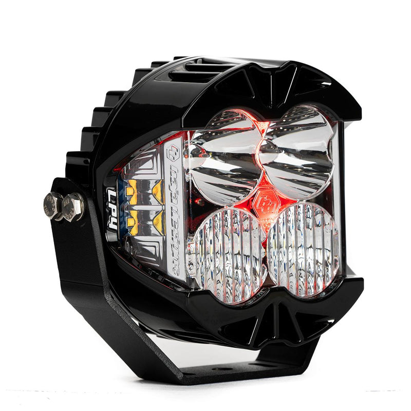Baja Designs LP4 Pro LED Auxiliary Light Pod, whole product on a studio background: A black LP4 Pro LED pod with clear lenses and a red colored backlight glowing, shown at an angle on white