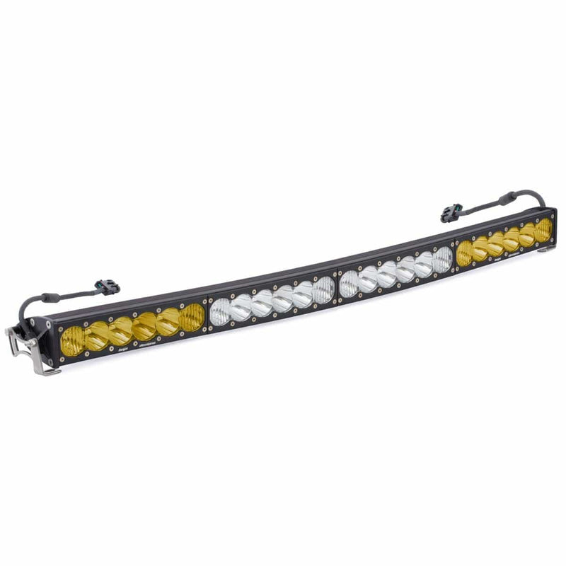 Baja Designs OnX6 Arc Dual Control LED Light Bar, whole product on a studio background: curved black LED light bar with amber end sections, clear center sections and wiring pigtails on a white background