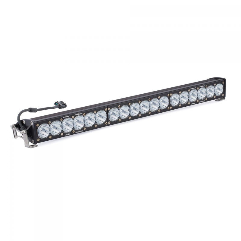Baja Designs OnX6 Straight Racer Edition LED Light Bar, whole product on a studio background: long black straight OnX6 Racer Edition LED light bar with clear lenses, end mounting brackets and a wiring pigtail