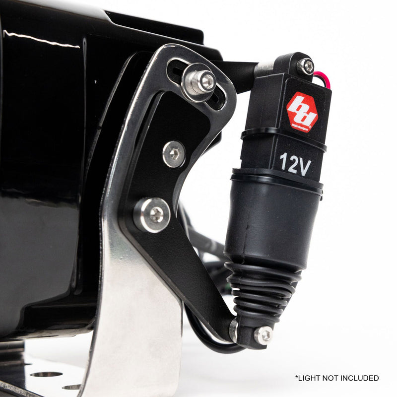 Close-up of the Baja Designs REFLEX Light Actuator Kit, XL Standard Housing: close view of the 12V REFLEX actuator bolted to the side bracket of an XL pod on white, with a small light-not-included note