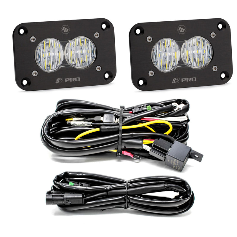 Baja Designs S2 Pro Black Flush Mount LED Light Pod Reverse Kit, complete kit on a studio background: two black S2 Pro flush mount LED pods with clear fluted lenses, a relay wiring harness and an extension harness on a white background