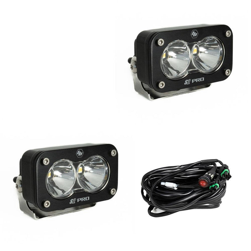Baja Designs S2 Pro Black LED Auxiliary Light Pod Pair, whole product on a studio background: two black S2 Pro LED pods with clear smooth spot reflector lenses and a wiring harness with switch on a white background