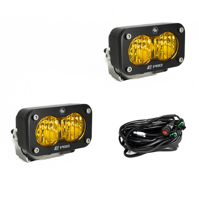 Baja Designs S2 Pro Black LED Auxiliary Light Pod Pair, whole product on a studio background: two black S2 Pro LED pods with amber fluted driving combo style lenses and a wiring harness with switch on a white background
