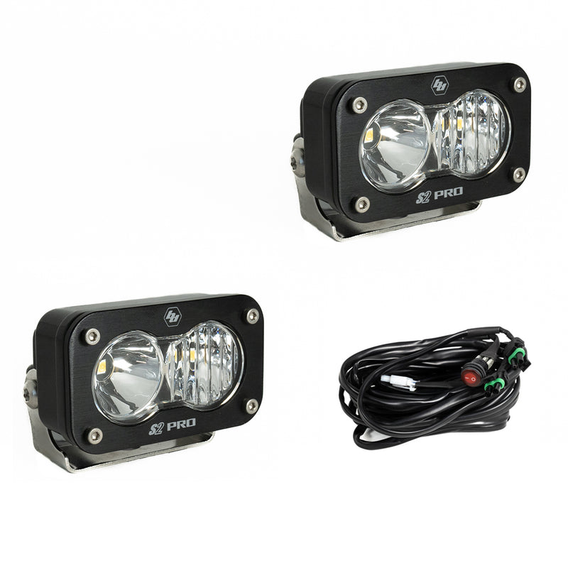 Baja Designs S2 Pro Black LED Auxiliary Light Pod Pair, whole product on a studio background: two black S2 Pro LED pods with clear smooth spot reflector and fluted lenses and a wiring harness with switch on a white background