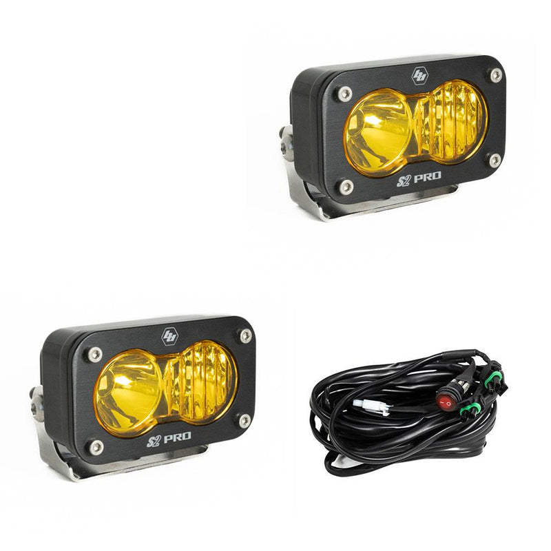 Baja Designs S2 Pro Black LED Auxiliary Light Pod Pair, whole product on a studio background: two black S2 Pro LED pods with amber smooth spot reflector and fluted lenses and a wiring harness with switch on a white background