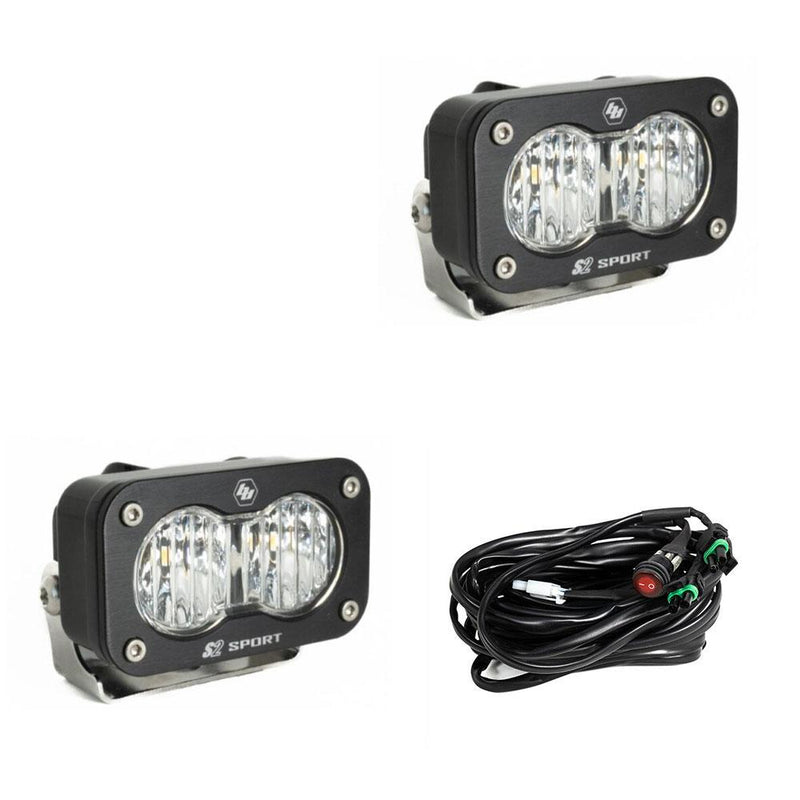 Baja Designs S2 Sport Black LED Auxiliary Light Pod Pair, whole product on a studio background: pair of black S2 Sport light pods with clear fluted wide cornering lenses and a wiring harness on a white background