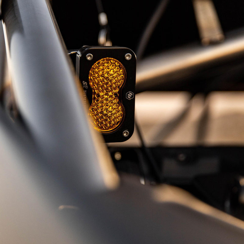 Baja Designs S2 Sport Universal Chase Light Kit on a vehicle: an S2 Sport pod with an amber honeycomb lens mounted vertically beside a roll cage tube