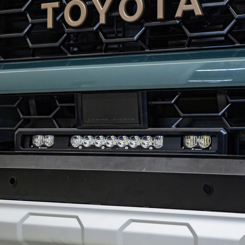 Baja Designs S8 10"/S2 Pro Grille Light Replacement Kit on a Toyota: close view of an S8 light bar and two S2 Pro pods mounted in the lower grille of a teal Toyota with TOYOTA grille lettering