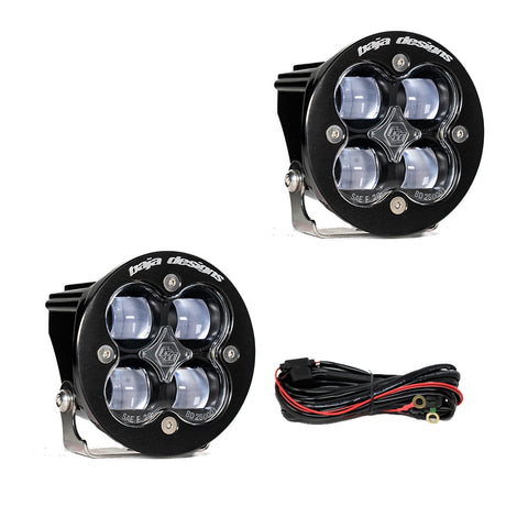 Baja Designs Squadron-R SAE LED Auxiliary Light Pod Pair, whole product on a studio background: two round black Squadron-R SAE pods with clear lenses and a wiring harness on a white background