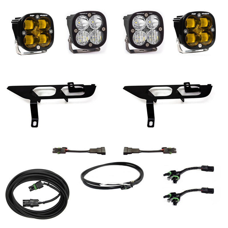 Baja Designs Squadron SAE/Pro Fog Pocket Light Kit, complete kit on a studio background: four black Squadron pods, two amber and two clear, two black fog pocket brackets, adapter harnesses and coiled cables on white; sibling 447700 is the amber kit