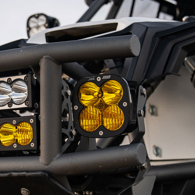 Baja Designs XL80 LED Auxiliary Light Pod Pair on a UTV (make not identifiable): A black Baja Designs XL80 LED pod with an amber lens mounted on the tube front bumper of a side-by-side next to smaller light bars