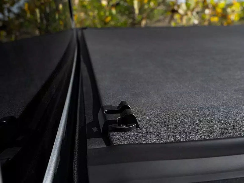 Close-up of the closed Revolver X4s matte top and side rail clip along the bed edge